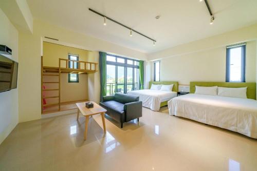 a hotel room with two beds and a chair at 太魯閣豐生活海館包棟民宿 T-aroko Fengst-ay Ocean Villa-------根據訂房人數提供相對的房間數量 Provide different number of rooms according to the number of people in the reservation in Shunan