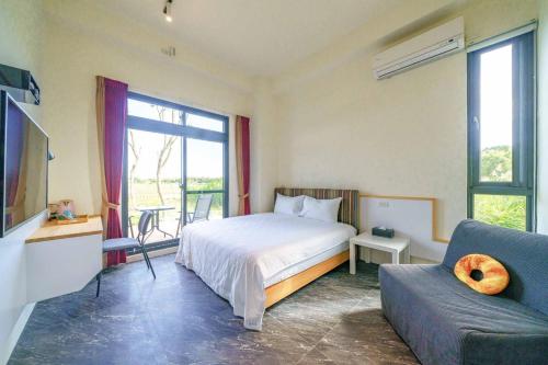 a bedroom with a bed and a couch at 太魯閣豐生活海館包棟民宿 T-aroko Fengst-ay Ocean Villa-------根據訂房人數提供相對的房間數量 Provide different number of rooms according to the number of people in the reservation in Shunan