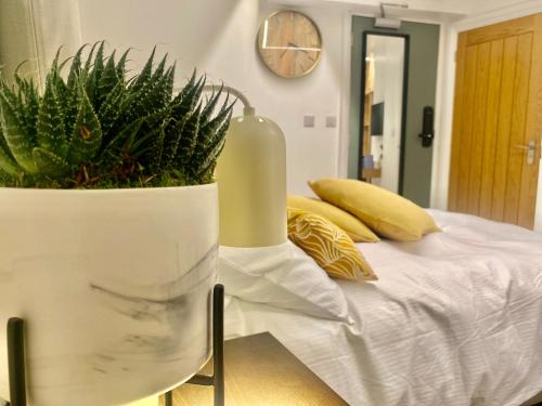 Un dormitorio con una cama con un jarrón con una planta en Station Rooms, en Winchester