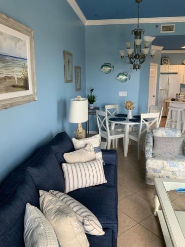 a blue living room with a couch and a dining room at VacayFun Condos-Phoenix VII 004 in Orange Beach