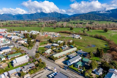 an aerial view of a town with mountains in the background at Anatoki Lodge Motel in Takaka
