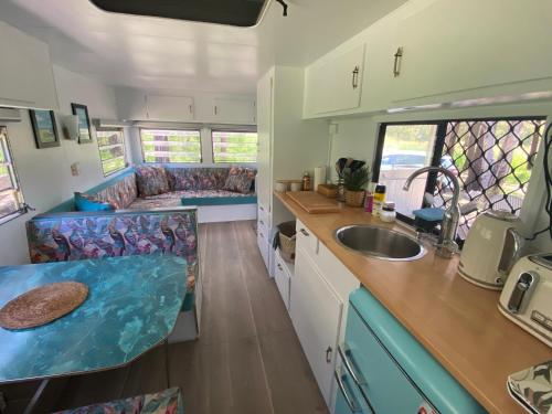 a kitchen and living room of an rv at Crescent Head, stylish retro caravan, deck, bathroom, private bush setting near beach in Crescent Head
