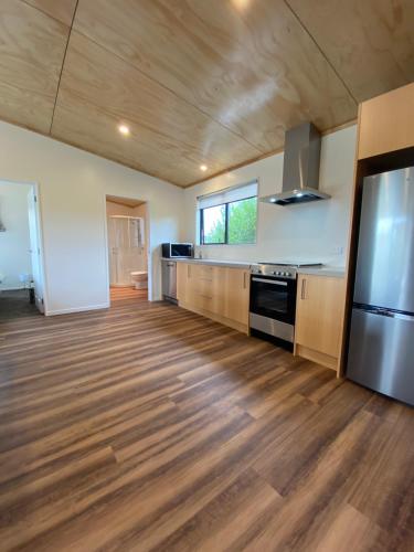a large kitchen with wooden floors and a large refrigerator at Country Retreats on Ranzau 7 in Hope