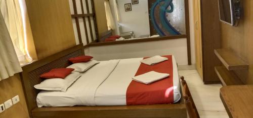 a bed in a room with a mirror at Hotel Aston in Kolkata