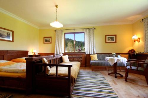 a bedroom with a bed and a couch and a window at Stangl - Hof in Bad Aussee