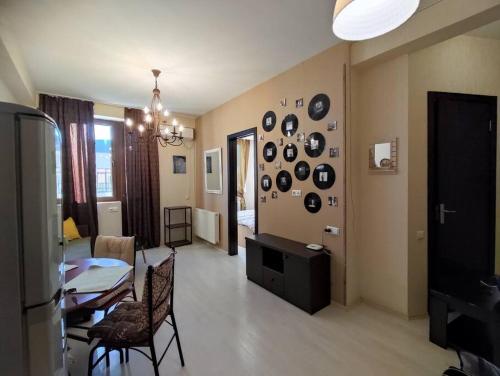 a living room with a table and a dining room at Уютная и светлая квартира с видом на горы in Tbilisi City