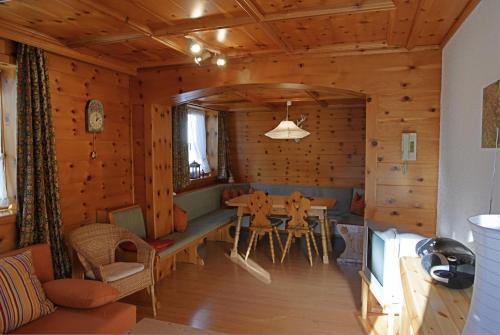 ein Wohnzimmer mit einem Tisch in einer Blockhütte in der Unterkunft Bergführer-Hüsle in Mittelberg