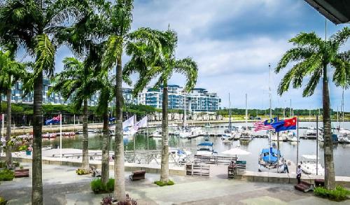 a marina with boats in the water and palm trees at Iskandar Residences 3 Bedroom in Nusajaya