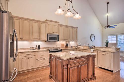 a large kitchen with wooden cabinets and a refrigerator at Upscale Home with Poker Room Less Than 1 Mi to Golf! in Aiken