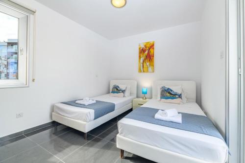 twee bedden in een kamer met een raam bij Blue Pelagos Villa in Protaras