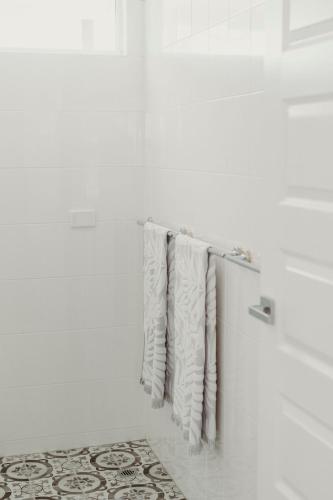 a row of white towels hanging on a wall at Nelson Palms in Nelson Bay