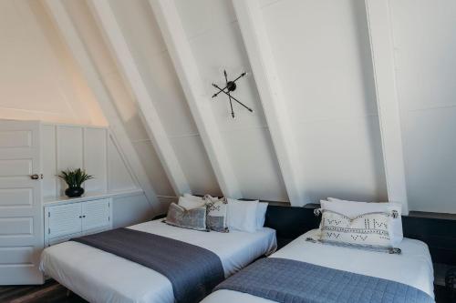 two beds in a room with a clock on the ceiling at Nelson Palms in Nelson Bay