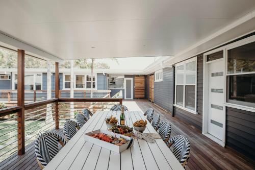 a white table and chairs on a deck at Nelson Palms in Nelson Bay