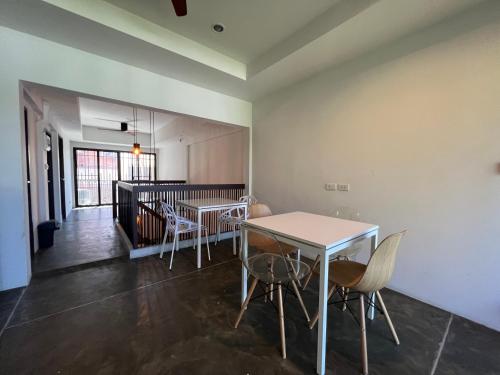 a dining room with two tables and chairs in a room at Litera Hostel in Hua Hin