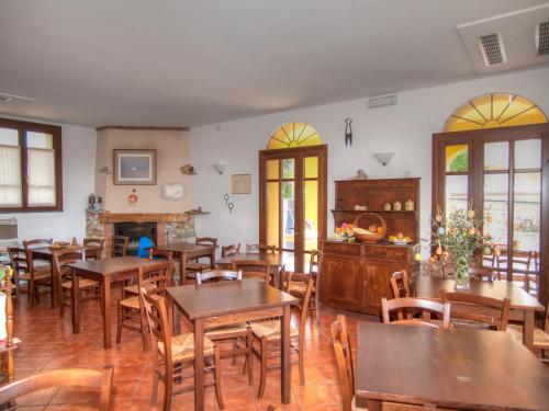 ピエトラ・リーグレにあるAgriturismo Ca' Di Trinciaのテーブルと椅子、暖炉のあるレストラン