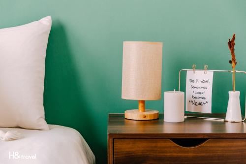 a lamp on a table next to a bed at Tainan Haian Art Apartment in Tainan