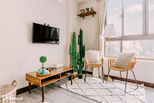 a living room with a tv and cactus at Tainan Haian Art Apartment in Tainan