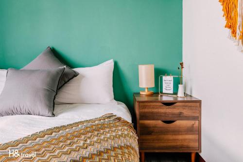 a bedroom with a bed and a night stand with a lamp at Tainan Haian Art Apartment in Tainan