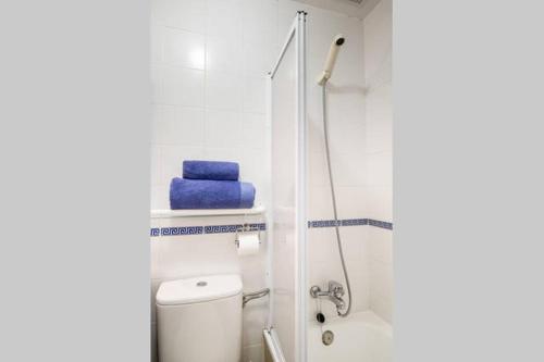 uma casa de banho com um WC e um chuveiro com toalhas azuis em Dorado Playa em Huelva