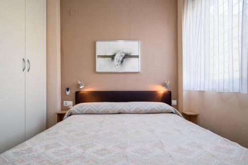 una camera con un letto con una foto sul muro di Dorado Playa a Huelva