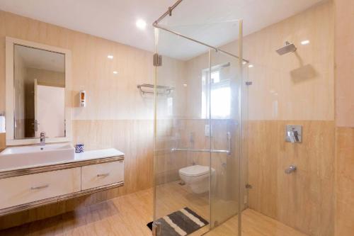 a bathroom with a shower and a toilet and a sink at StayVista at Starry Deck with Pvt Pool & Terrace Access in Chennai