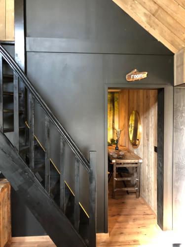 a hallway with a black wall and a wooden staircase at Logement Bilderdam in Leimuiden