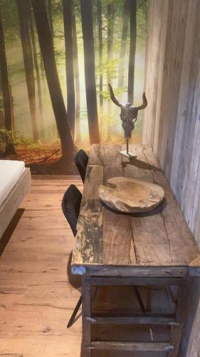 a wooden table with a bull head in the woods at Logement Bilderdam in Leimuiden