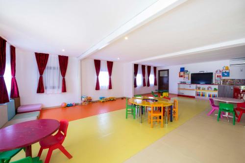 a room with tables and chairs and a kitchen at Armas Bella Sun in Side