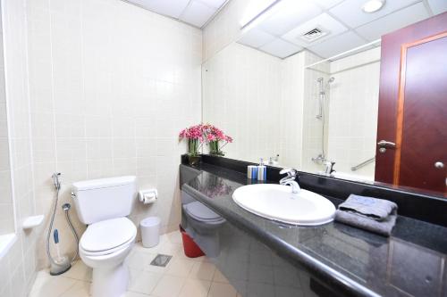 a bathroom with a sink and a toilet and a mirror at Spacious Fully Furnished Studio Apt - Next to Metro, 5 Mins from Mall - TNY in Dubai
