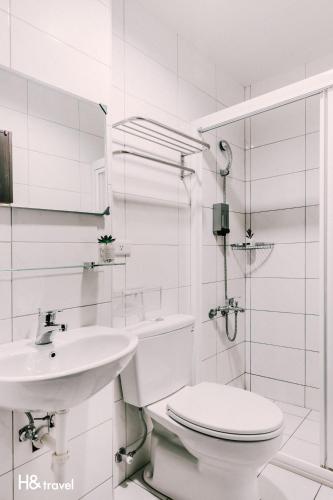 a white bathroom with a toilet and a sink at Tainan Haian Art Apartment in Tainan