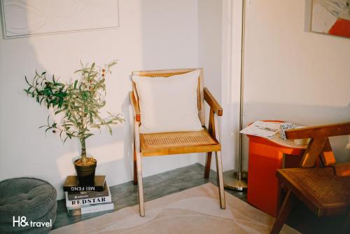 a wooden chair in a room with a plant at Tainan Haian Art Apartment in Tainan