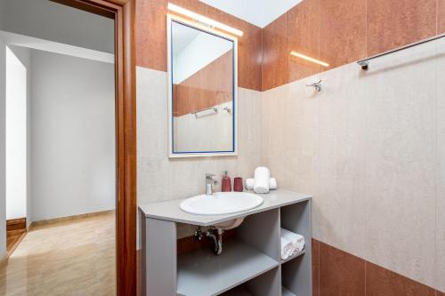 a bathroom with a sink and a mirror at Siena Pool Villa in Koskinou
