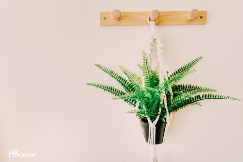 a cross hanging on a wall with a plant at Tainan Haian Art Apartment in Tainan