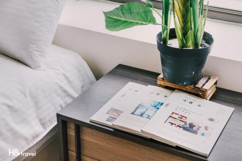 a table with a book and a potted plant on it at Tainan Haian Art Apartment in Tainan