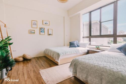 a bedroom with two beds and a window at Tainan Haian Art Apartment in Tainan