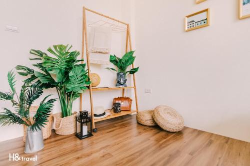 a room with plants and a mirror on a wooden floor at Tainan Haian Art Apartment in Tainan