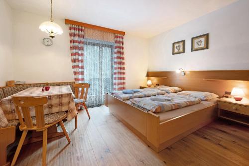 a bedroom with a bed and a table and a desk at Heiserhof App Holunder in Val di Mezzo