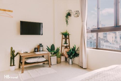 a white room with potted plants and a flat screen tv at Tainan Haian Art Apartment in Tainan