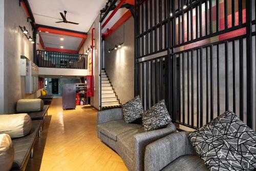a living room with two couches and a staircase at Buri Hostel Bangkok in Amphoe Phra Khanong