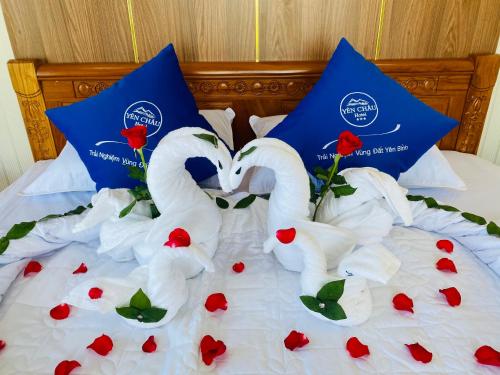 two white swans making a heart shape on a bed at khách Sạn Yên Châu in Chau Doc