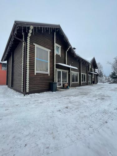 a building with snow on the ground in front of it at Карпатська Криївка in Yasinya