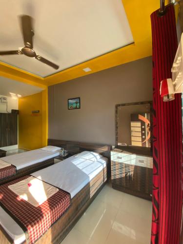 a room with two beds and a mirror at APURBA GUEST HOUSE in Jorhāt