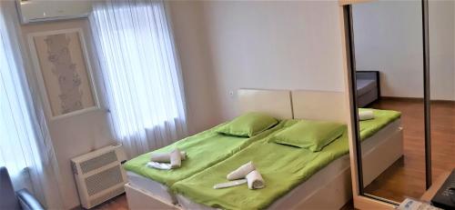 トビリシにあるTamara`s Apartament in Avlabariのベッドルーム(緑のベッド1台、鏡付)