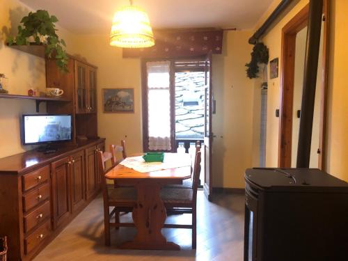 a dining room with a table and a television at La Losa in Brusson