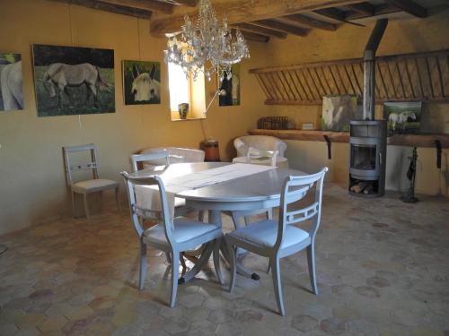 une salle à manger avec une table et des chaises blanches dans l'établissement Le Pautonier, à Saint-Aubin-des-Grois