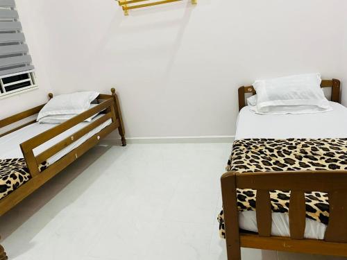 two beds in a room with white walls at ADDA Guest House in Kota Bharu