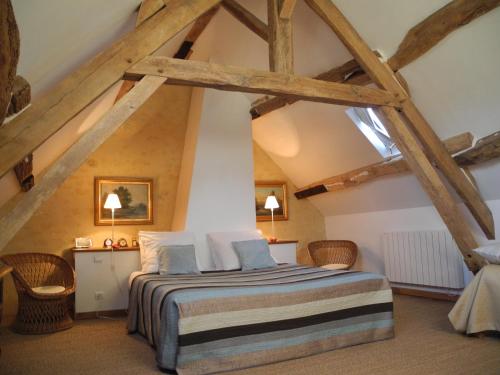 een slaapkamer met een bed op zolder bij Le Pautonier in Saint-Aubin-des-Grois
