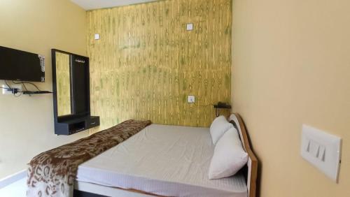 a small bedroom with a bed and a television at ANAND LOK VATIKA in Rājgīr