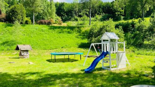 a playground with a slide and a playset in a field at Chalupa u Bohumila in Rybná nad Zdobnicí