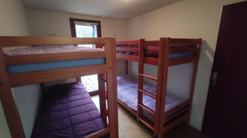 two bunk beds in a room with a window at Les gîtes de Beille in Les Cabannes